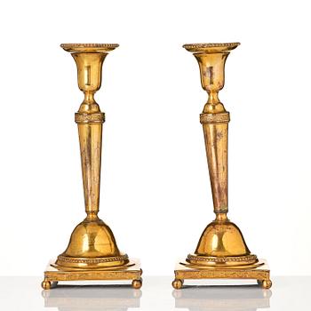 A pair of late George III gilt-copper candlesticks, early 19th century.