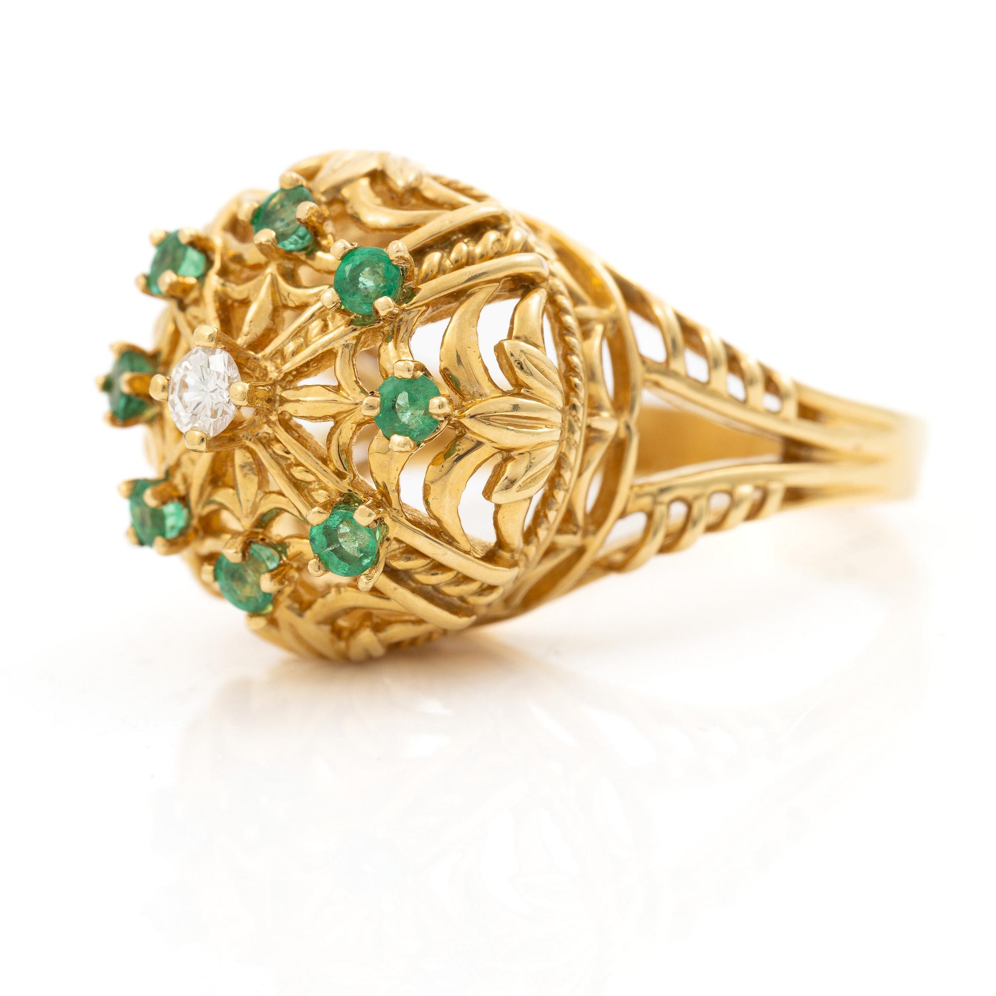 18K gold ring with small emeralds and a round brilliant-cut diamond.
