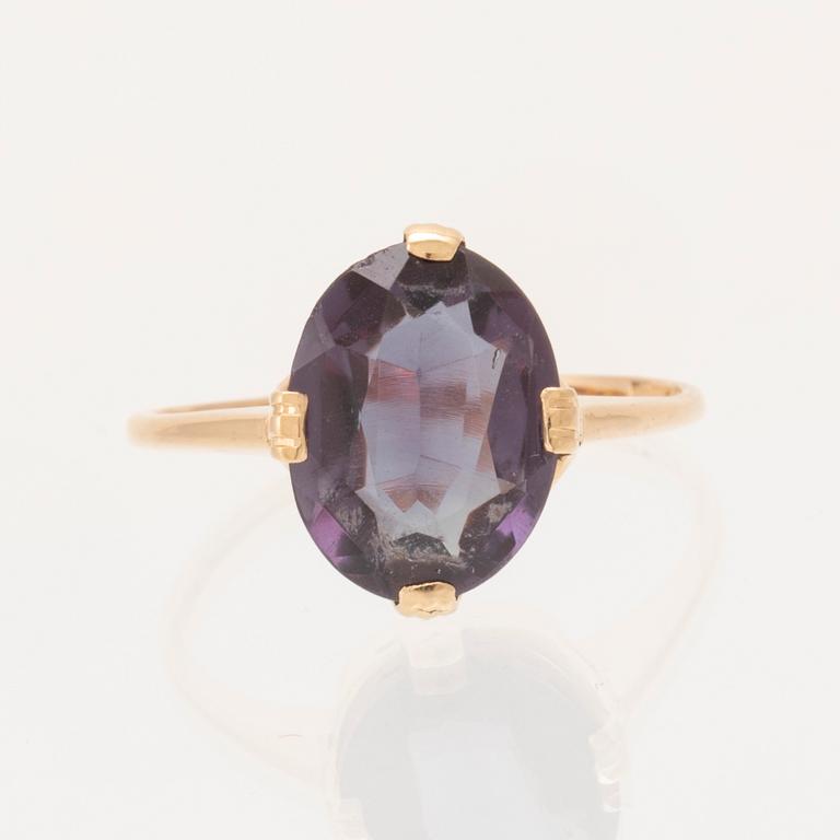 An 18K gold ring set with a synthetic colourchange purple sapphire.