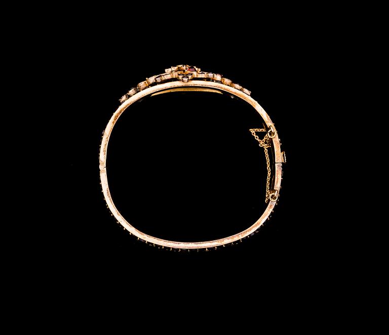 ARMRING, förgyllt silver med granater. Omkring 1900.