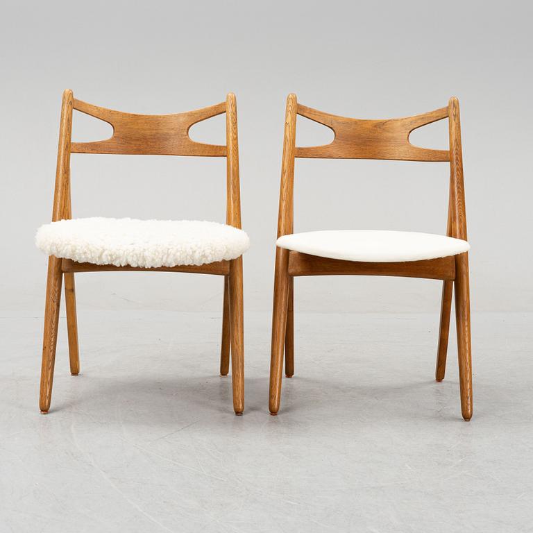A set of six model CH 29 oak chairs by Hans J Wegner, two with leather upholstery and four with sheepskin.