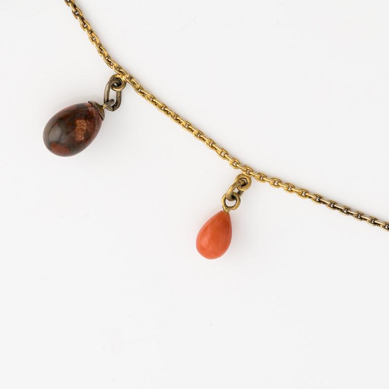 Necklace with jeweled egg, 14K gold and metal.
