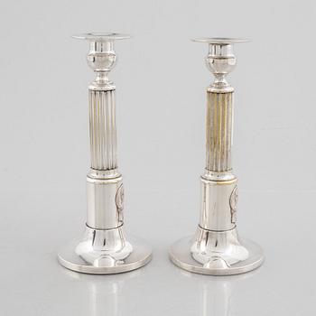 A pair of candlesticks and a commemorative pin from the Olympic Games in Stockholm 1912.
