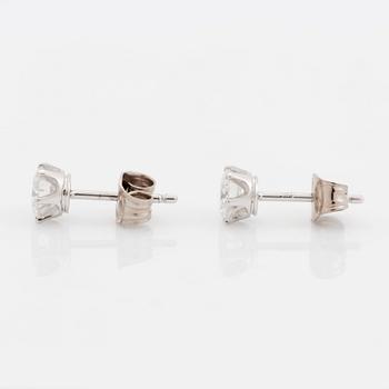 A pair of 18K white gold earrings set with two round brilliant-cut diamonds.