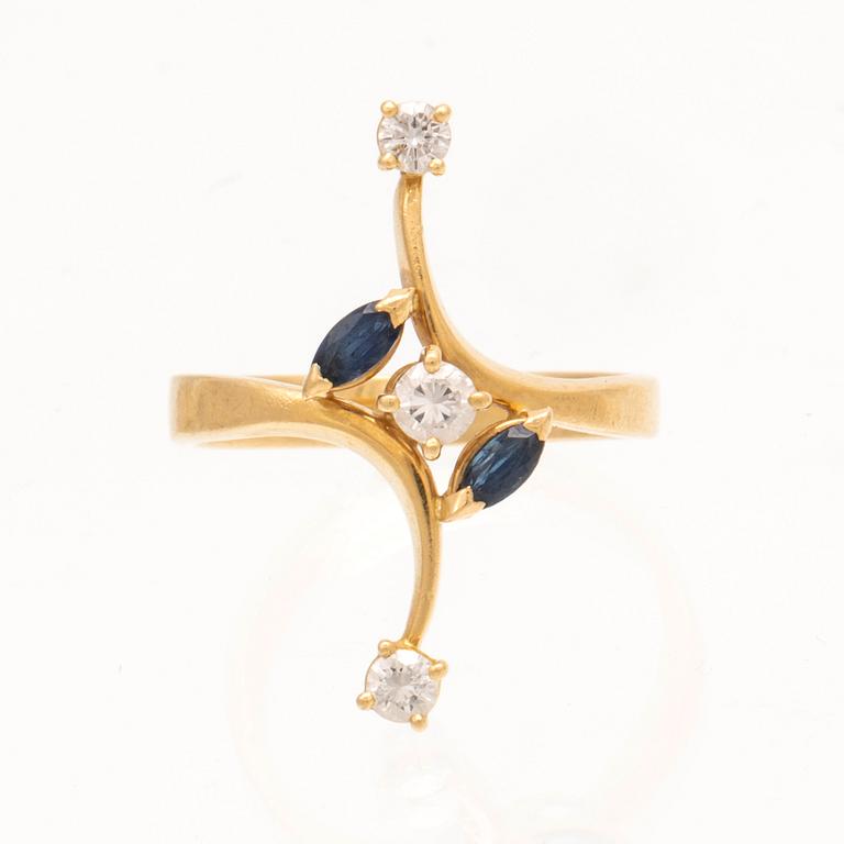 An 18K gold ring with marquise cut sapphires and round brilliant cut diamonds.