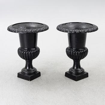 A pair of cast iron garden urns, 20th century.