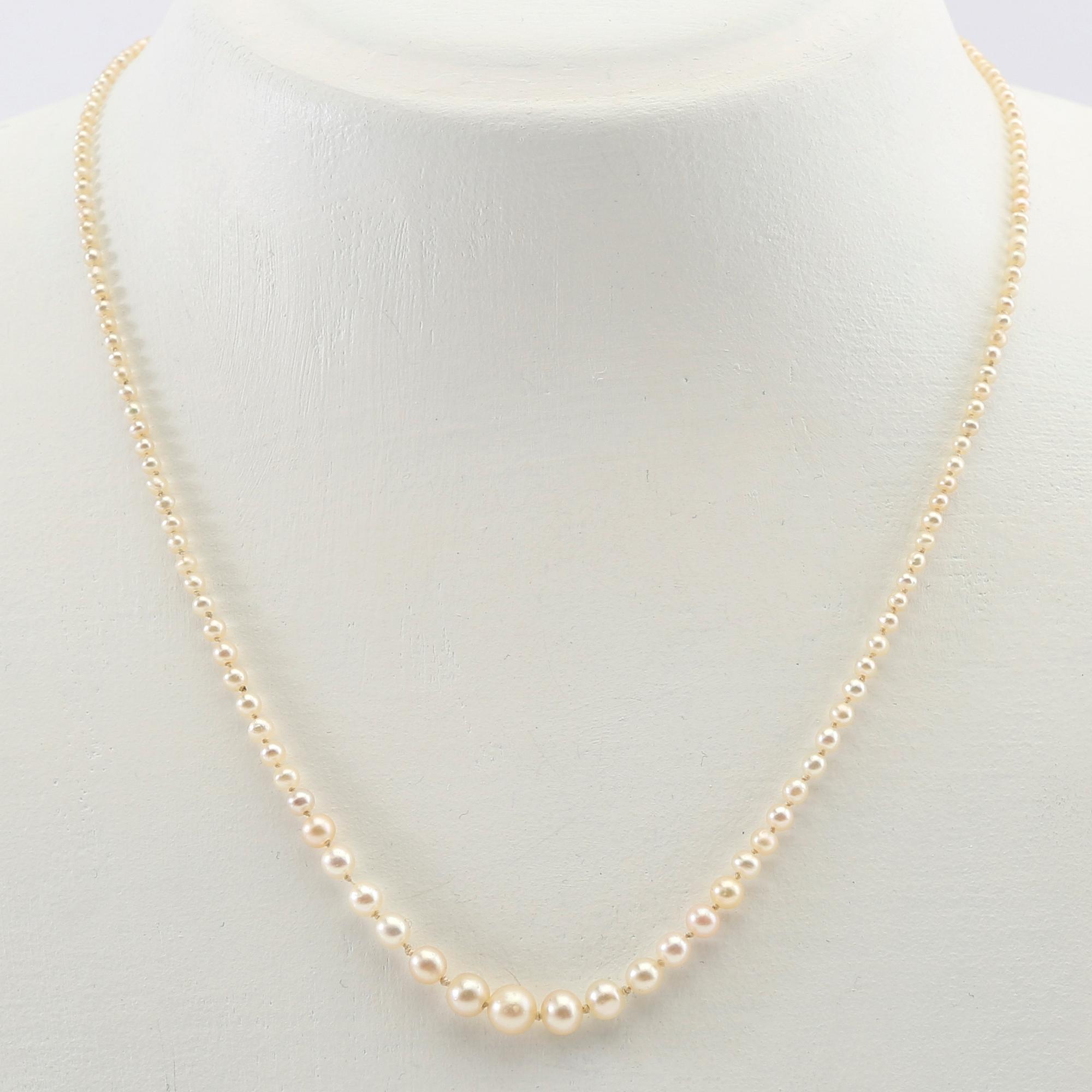 Necklace of cultured pearls with a clasp of gold set with diamonds.
