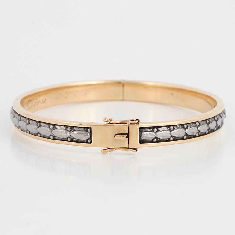 An 18K gold bangle.