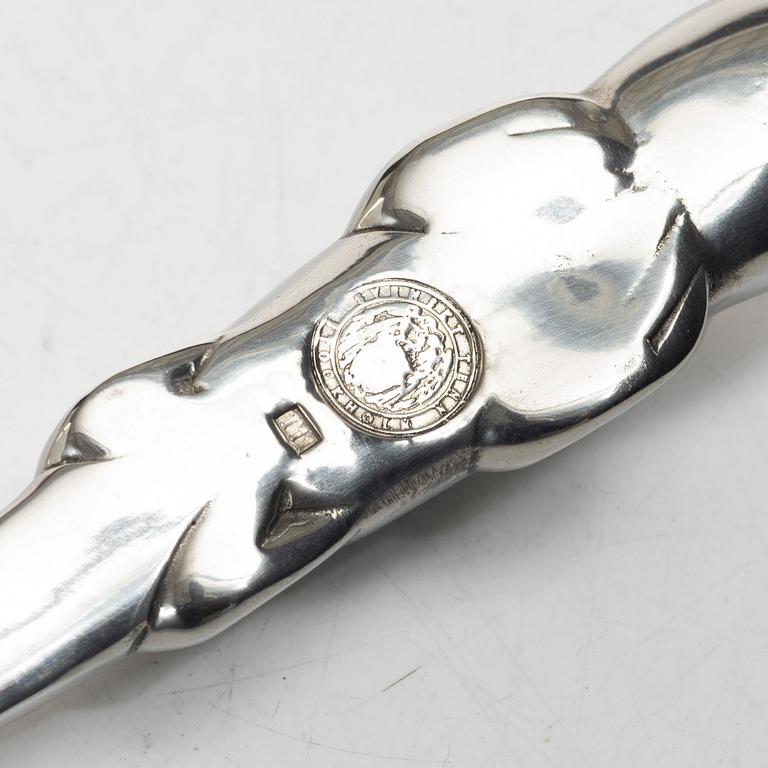 Firma Svenskt Tenn, Candelabrum, 'Vänskapsknuten', and paper knife, 'Alligator'.