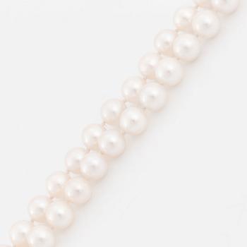 A cultured pearl necklace with a 14K white gold bow pendant set with round brillliant-cut diamonds.