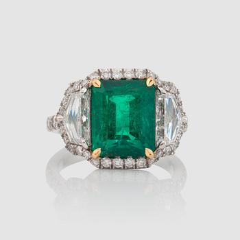 1144. An emerald, 5.50 cts, flanked by epaulette-cut diamonds 1.55 cts and pavé-set diamonds circa 0.80 cts, ring.
