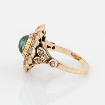 A 14K gold ring set with a cabochon-cut emerald and old-cut diamonds.