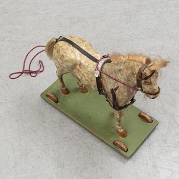 A painted early 20th century toy horse on wheels.