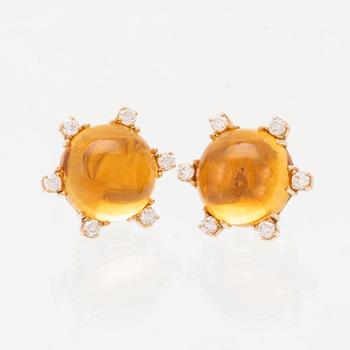A pair of 18K gold earrings set with cabochon cut citrines and round brilliant cut diamonds.