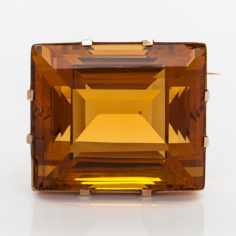 A ca 13K gold brooch, set with a step-cut Madeira citrine approximately 119.0 ct.