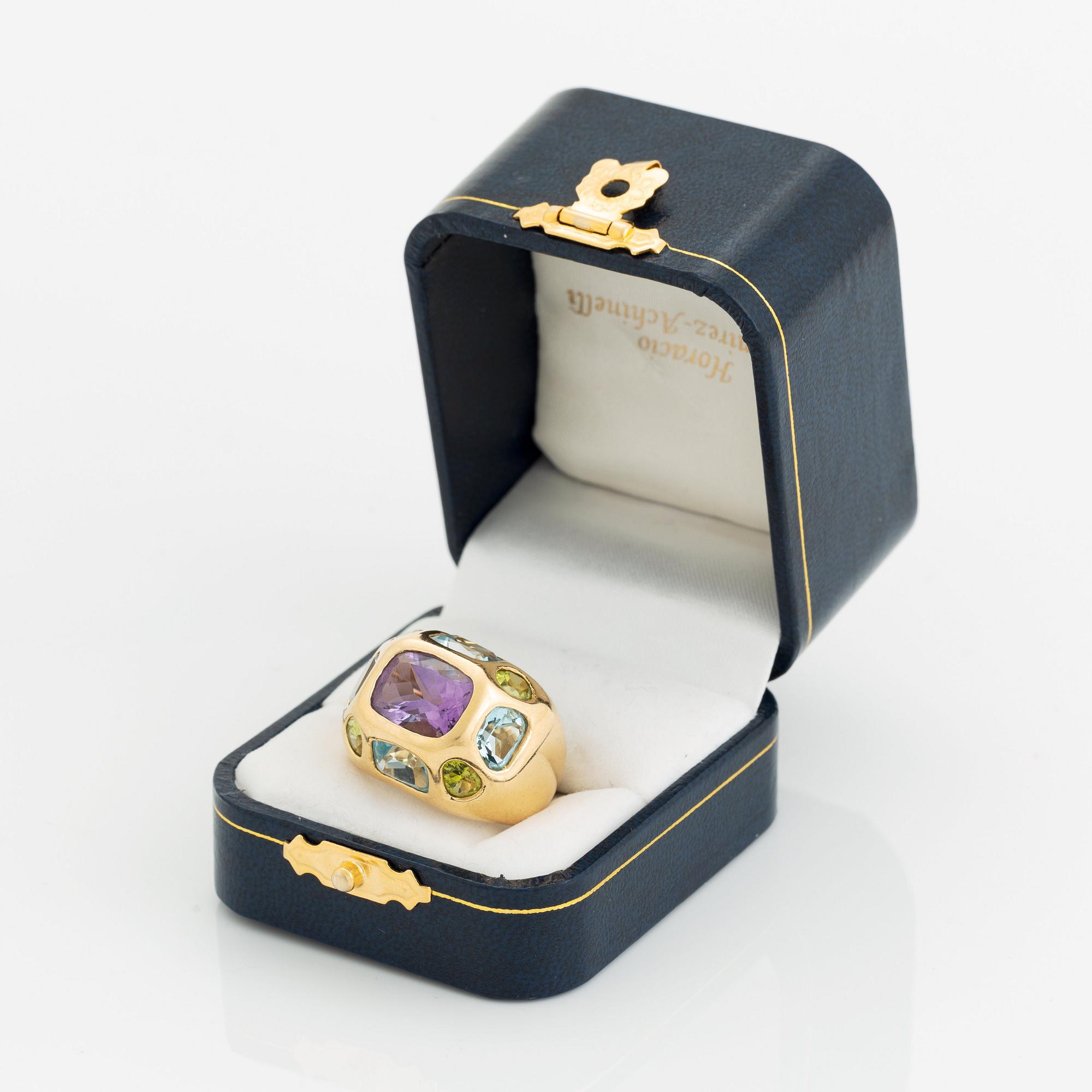 An 18K gold ring set with faceted amethyst, peridot and aquamarine.