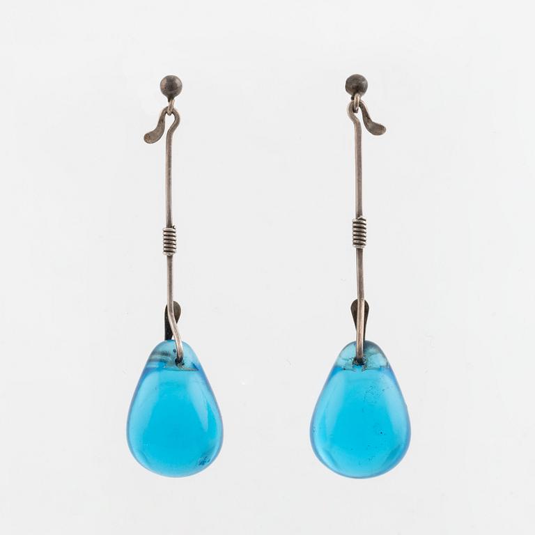 A pair of silver earrings with blue glass drops, likely by Torun Bülow-Hübe.