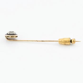 An 18K gold brooch pin with an old-cut diamond.