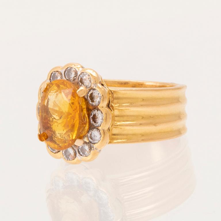 A 22K gold carmosé ring with an oval faceted yellow sapphire and round brilliant-cut diamonds.