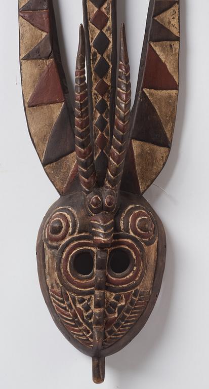 A sculptue and two masks reportedly from The Ivory coast, from the second half of the 20:th century.