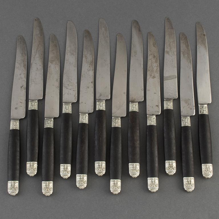 A set of twelve French 19th century ebony with silver dinner-knifes, unmarked.