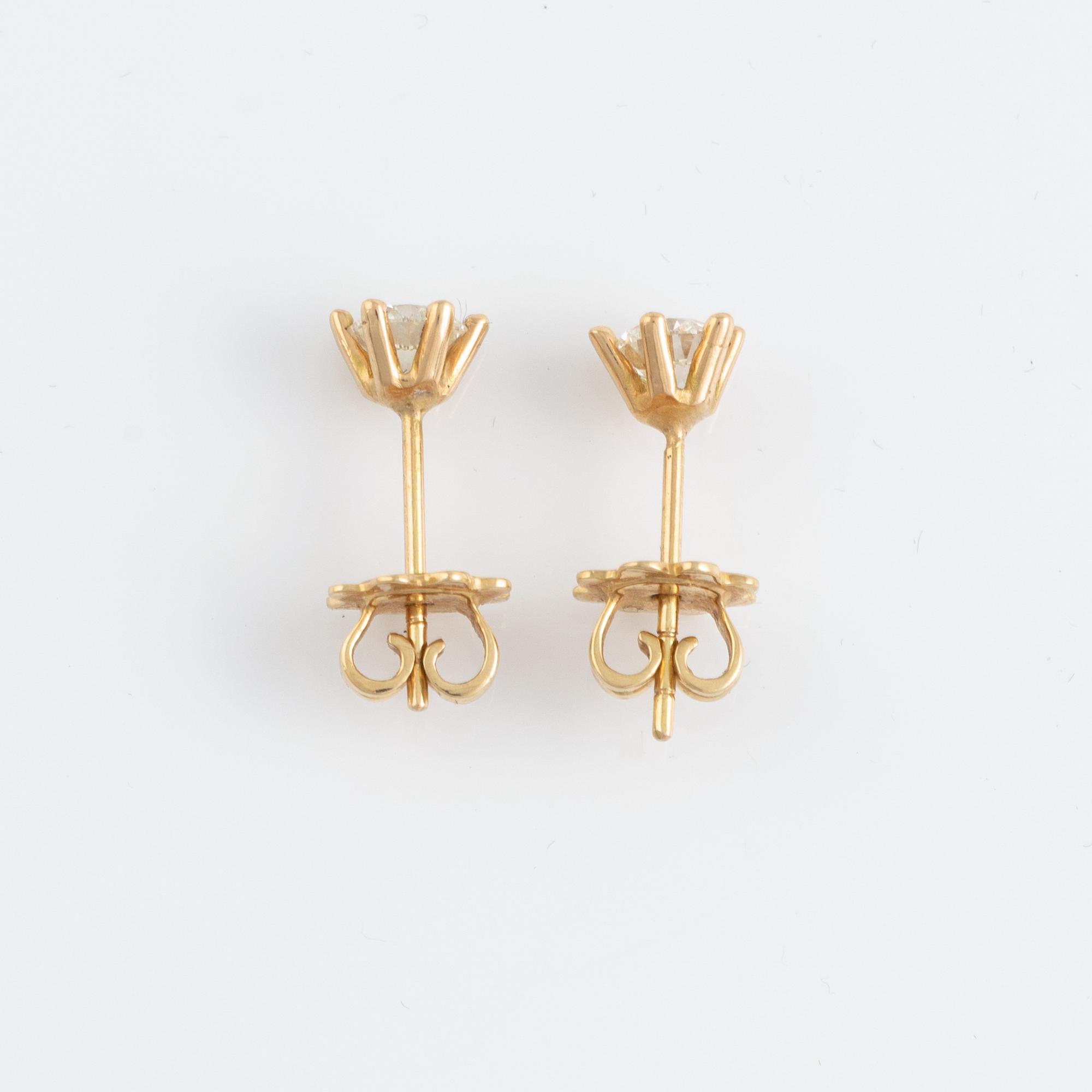 Ett par örhängen guld med runda briljantslipade diamanter.