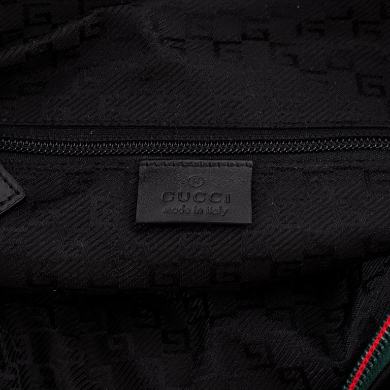 Gucci, a black canvas backpack.