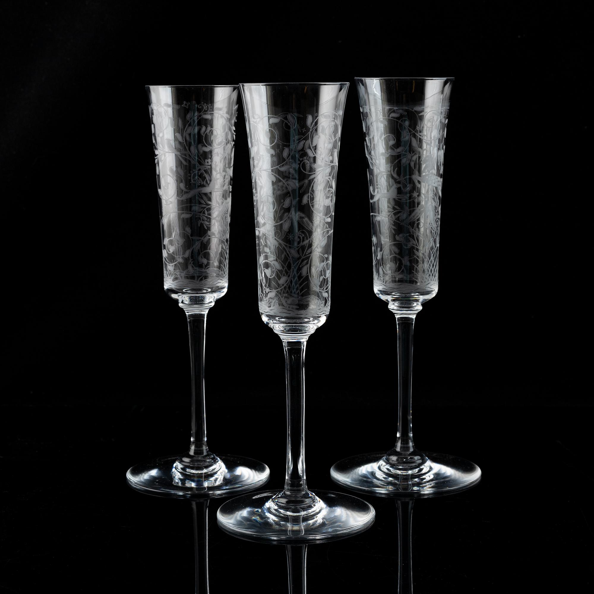 A set of 18 champagne flutes, engraved with animals and leafwork, 20th century Europe .