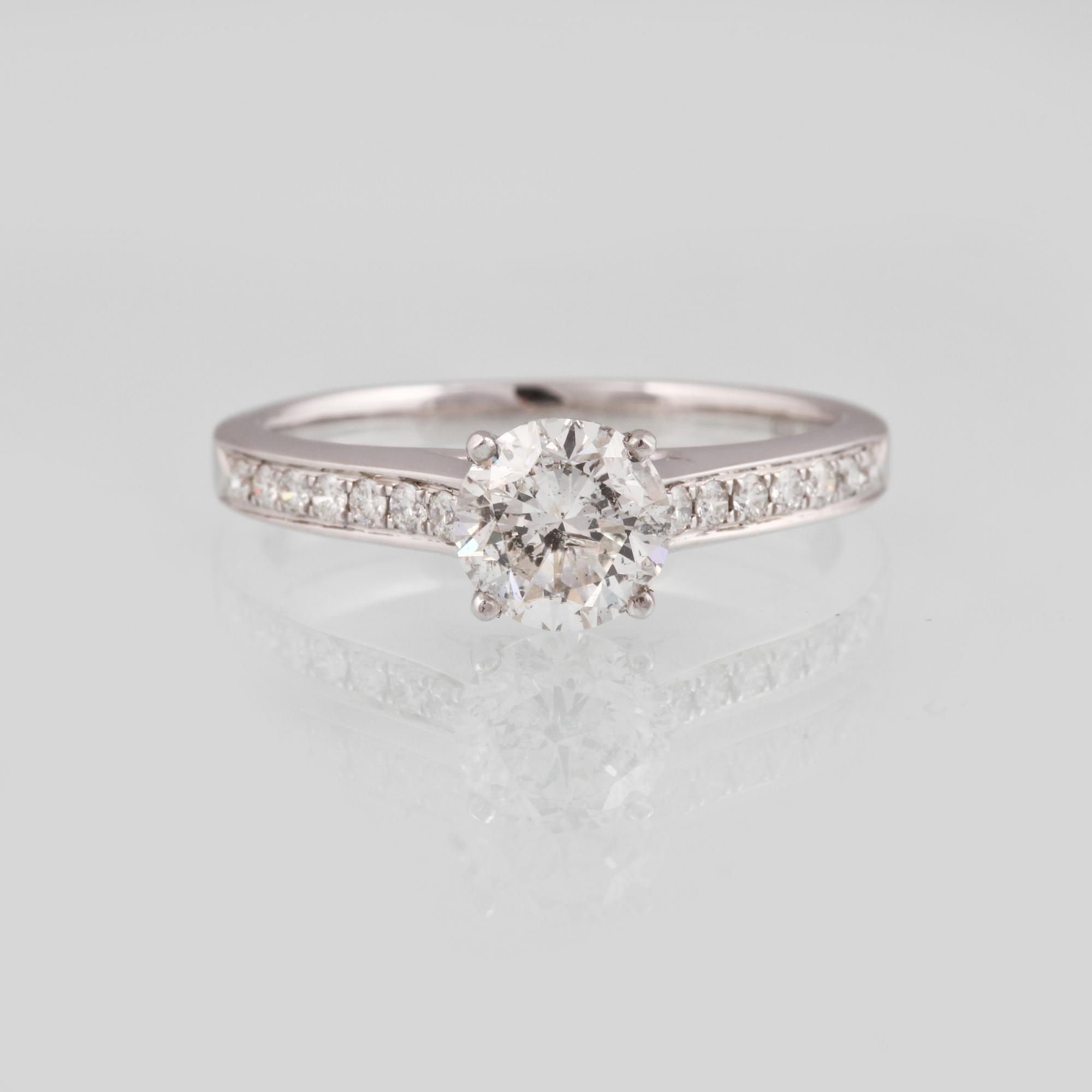 RING, 18K vitguld med briljantslipad diamant ca 0.85 ct samt 14 briljantslipade diamanter 0.15 ct. Vikt 3,1 gram.