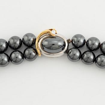 Ole Lynggaard. 2 rows of hematite beads with a clasp in 14K white gold and gold with a brilliant-cut diamond.
