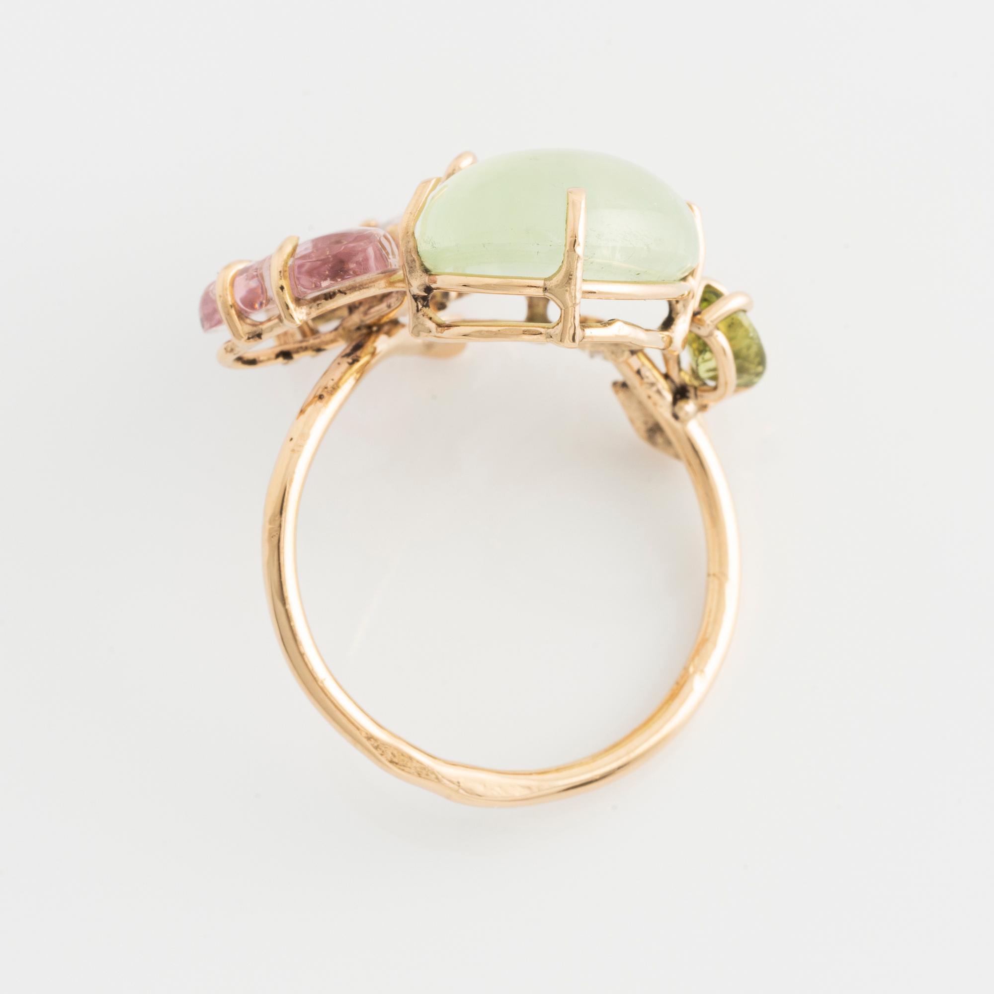Ring with cabochon-cut prehnite, cut tourmaline in the shape of a butterfly, peridot, and brilliant-cut diamonds.