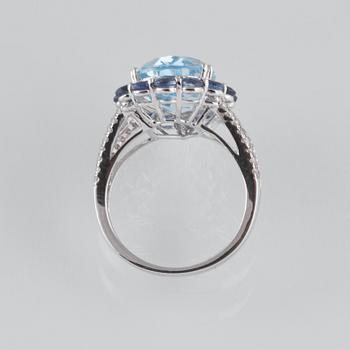RING, 18K vitguld med briljantslipade diamanter ca 0.24 ct, blå safirer ca 2.05 ct samt topas ca 6.93 ct. Vikt 5,6 g.