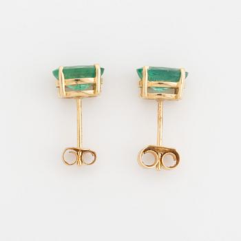Gold and oval emerald earrings.