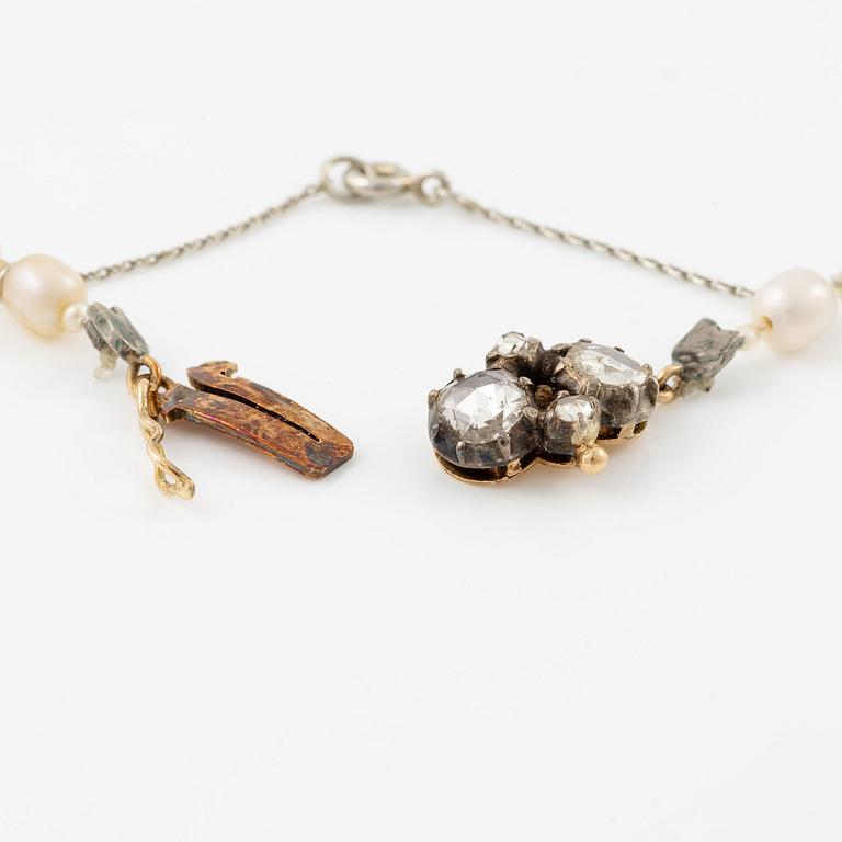A pearl necklace clasp in silver and 18K gold with rose-cut diamonds.