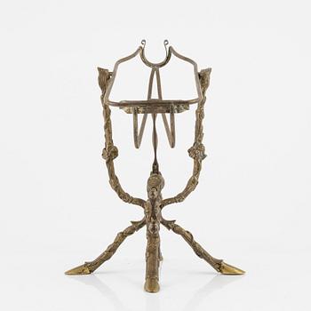 A brass bottle holder, circa 1900.