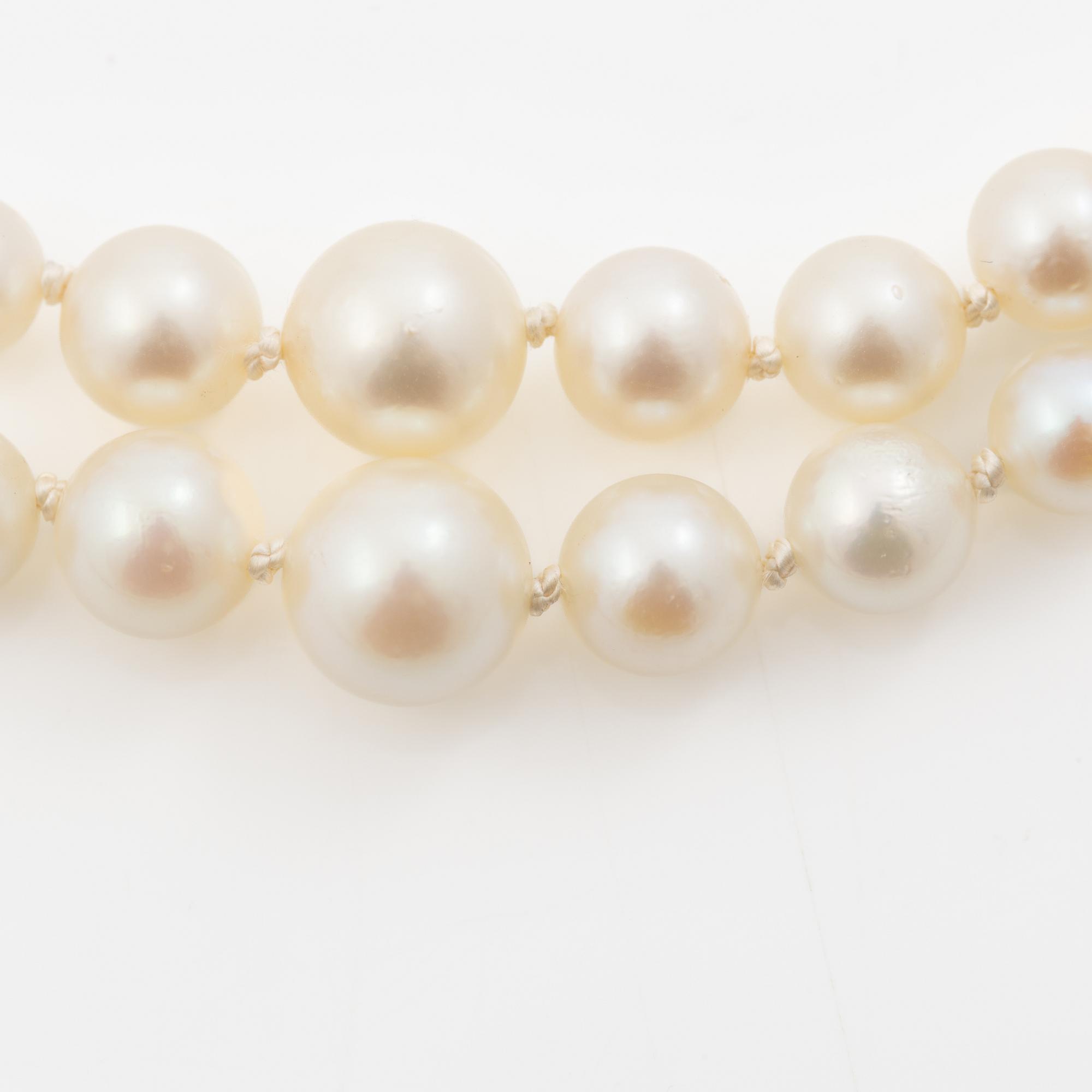 Double-row necklace with graduated cultured pearls, silver clasp set with paste stones.