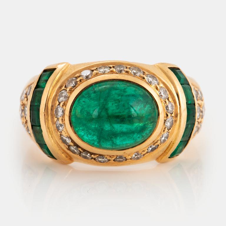 An 18K gold ring set with a cabochon-cut emerald.