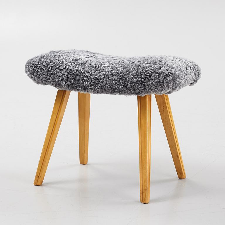 A birch stool with new sheepskin upholstery.