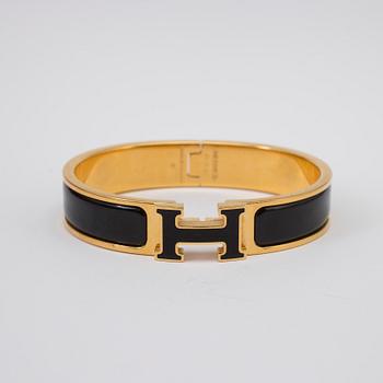 Black enamel and golden bracelet "Clic H" by Hermès.