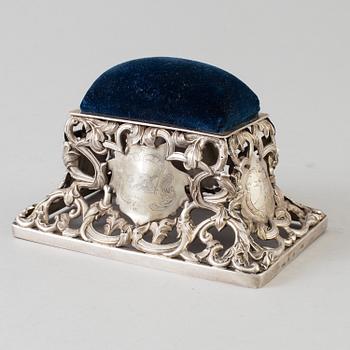 A Swedish 19th century silver pincushion and an English early 20th century pinstand.