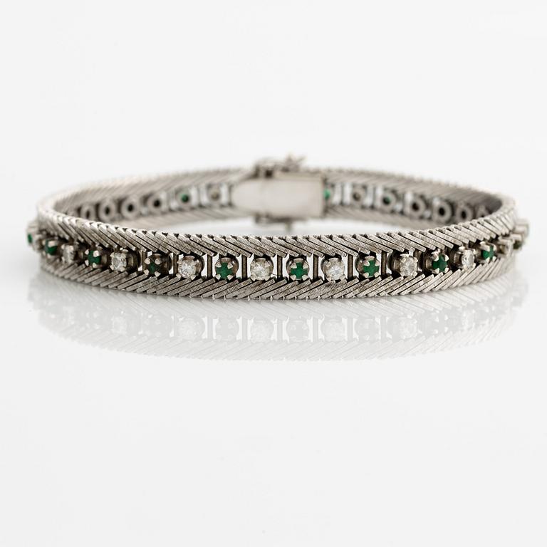 Bracelet 18K gold with round brilliant-cut diamonds and green stones, likely emeralds.