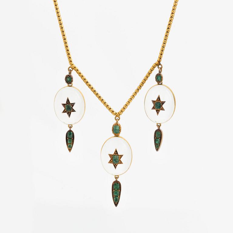 A Victorian 18K gold necklace with rock crystal set with green stones, possibly emeralds. Around 1880.