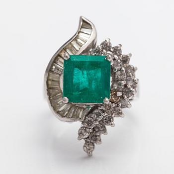 A platinum ring with a ca. 3.20 ct emerald and diamonds ca. 1.16 ct in total.