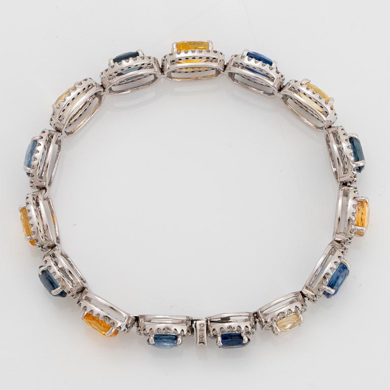 An 18K white gold bracelet set with faceted blue and yellow sapphires with a total weight of 25.80 cts.