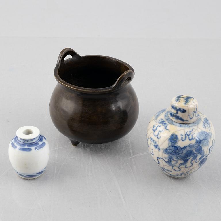 A Chinese bronze tripod censer and two miniature porcelain urns, late Qing dynasty/around 1900.