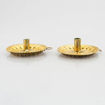 A set of three repousee brass candlesticks, 18th century.