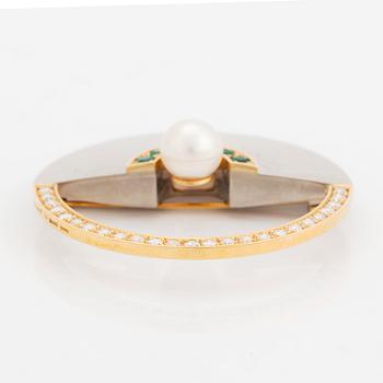 An 18K gold and white gold brooch set with a cultured pearl, round brilliant-cut diamonds and emeralds.