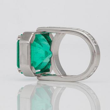 A 26.60ct emerald-cut Colombian emerald and radiant- and step-cut diamond ring.