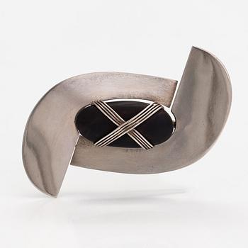 Paula Häiväoja, a sterling silver brooch with a natural stone "kiveen sidottu musta". Pentti Roos/Studio Paula, Helsinki.