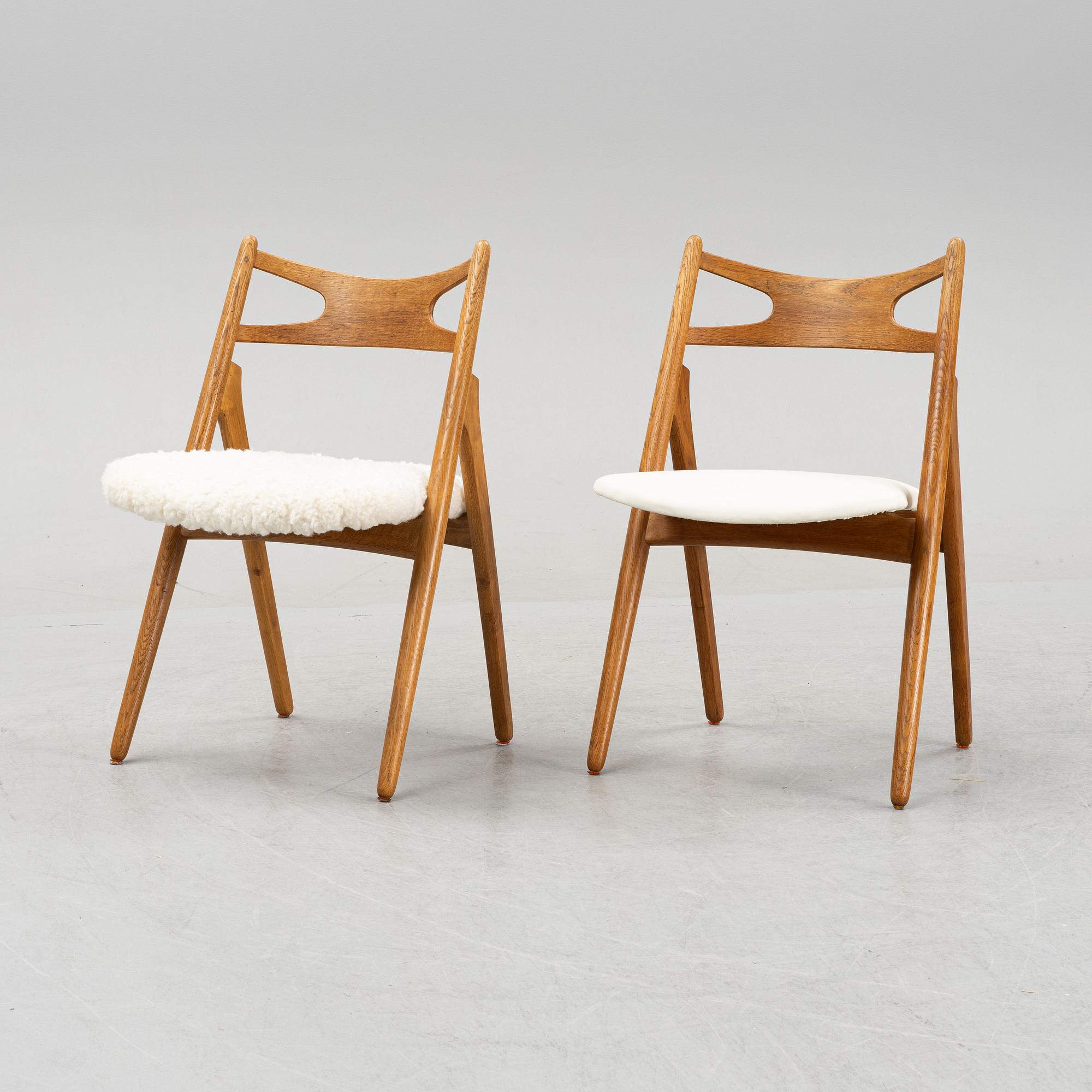 A set of six model CH 29 oak chairs by Hans J Wegner, two with leather upholstery and four with sheepskin.